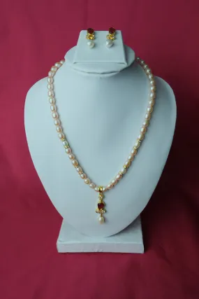 Cream color oval shape single line medium size fresh water cultured pearl necklace with pearl pendent along with jhumkas.